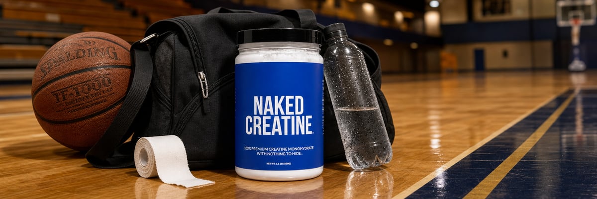 Naked Creatine tub beside a basketball and athletic bag on an indoor court sideline.